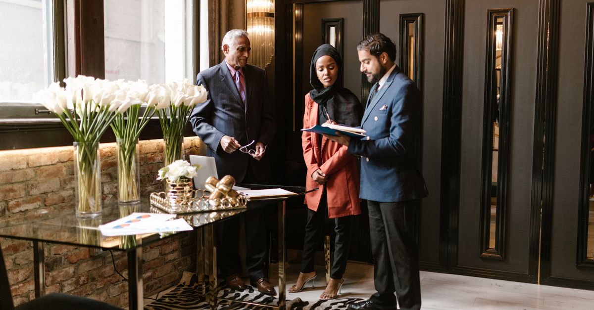 Professionals discussing in an elegant hotel lobby with luxurious interior design and decor.