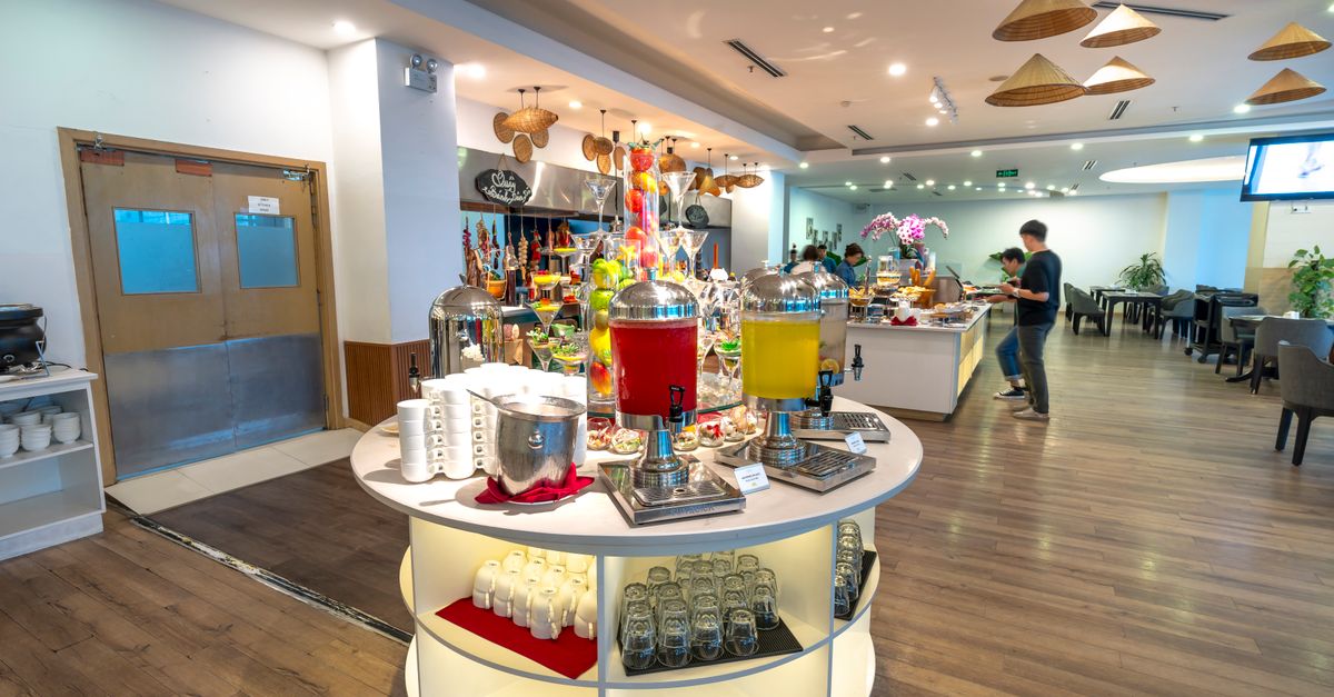 Spacious hotel buffet area with a variety of drinks and seating arrangements.