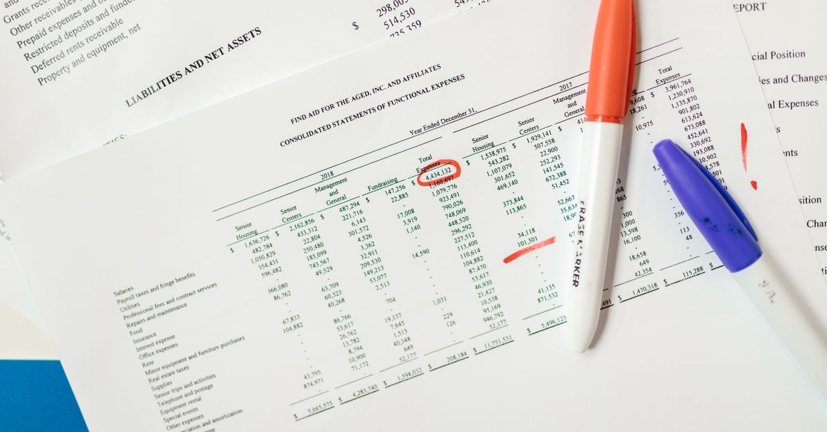Close-up of financial documents with highlighted figures and marker pens.