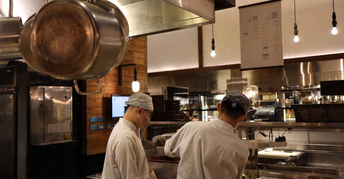 Two chefs working in a professional kitchen, highlighting culinary expertise and teamwork.