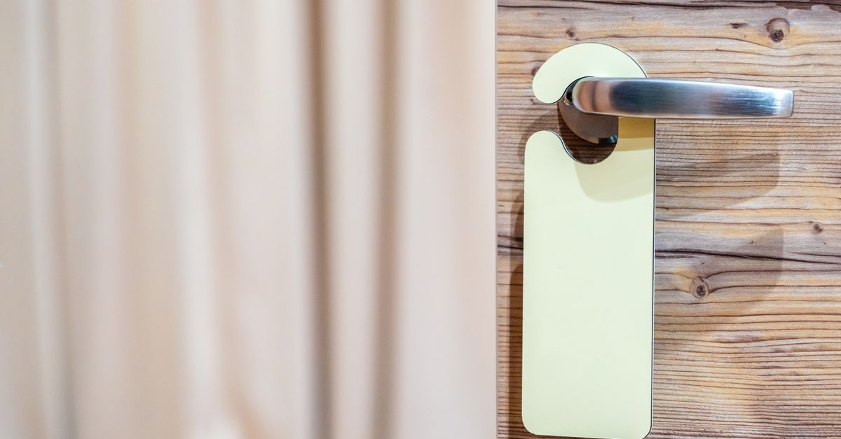 Elegant wooden door with a stainless steel handle and hotel tag.