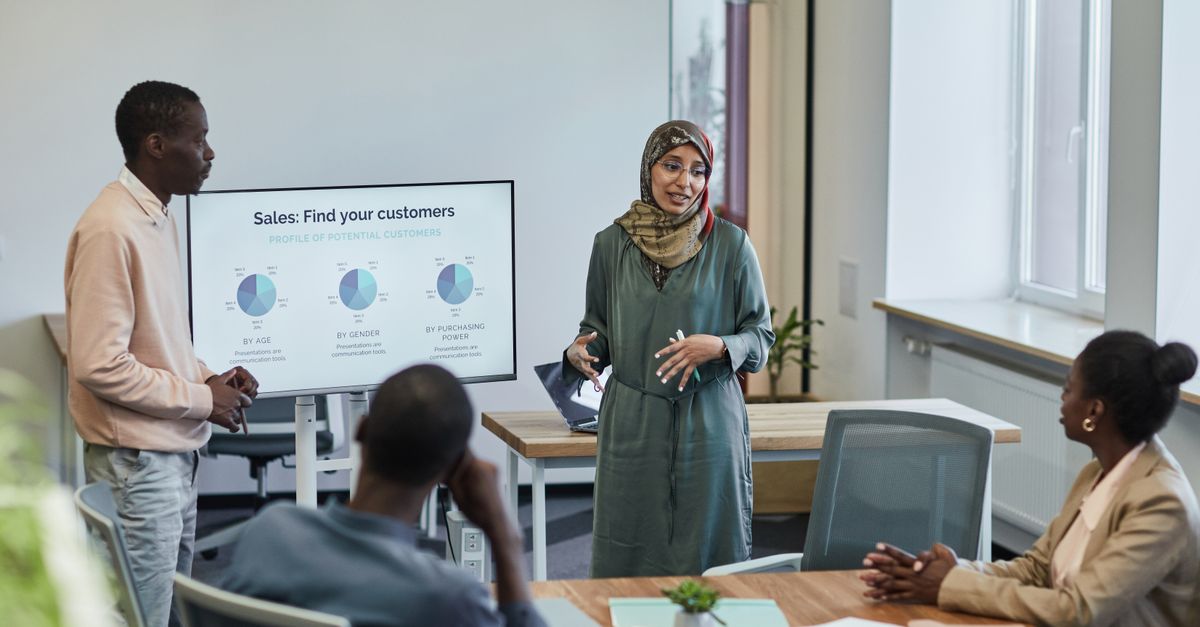 A diverse group of professionals in a business meeting discussing sales strategies.
