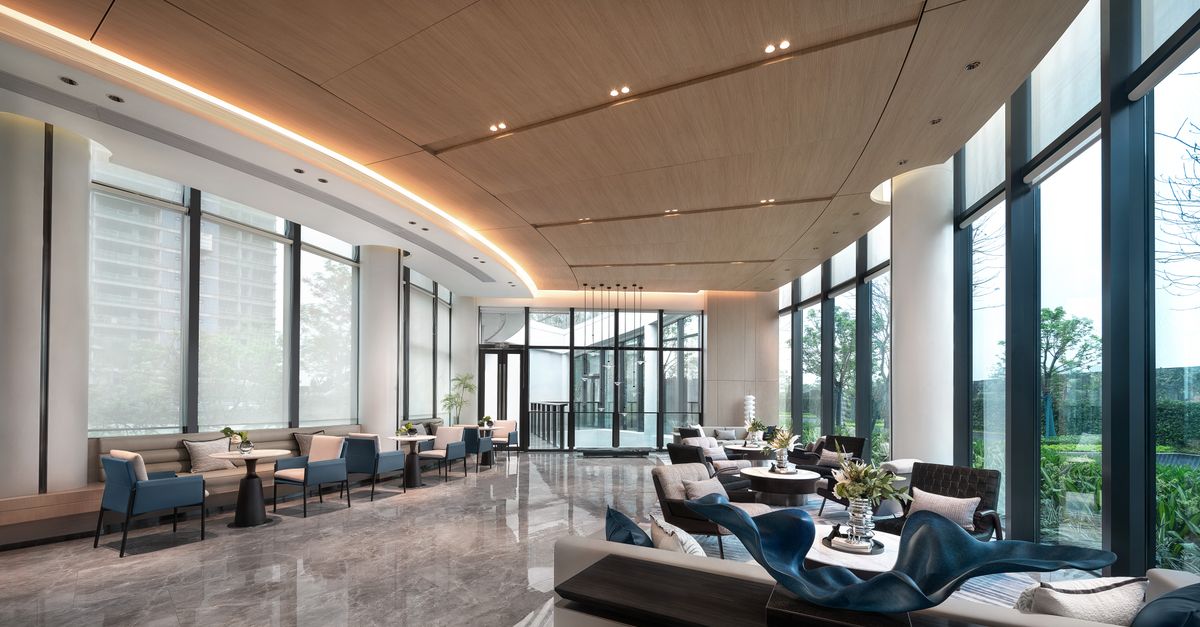 Spacious and elegantly designed luxury hotel lobby with modern furnishings and large windows.